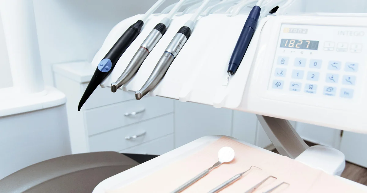 Cadeira odontológica moderna em consultório limpo com instrumental dentário organizado em mesa