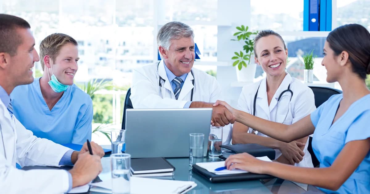 Três médicos em mesa de reunião analisando contrato social de sociedade médica em 2026